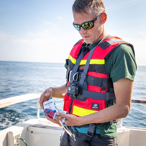Andreas Sundelöf till havs, hållandes en sändare som ska sättas på en blåfenad tonfisk.