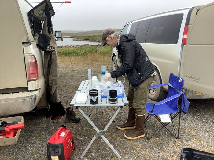 Person working with lab equipment outdoors. Photo.