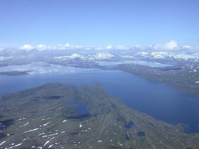 Flygbild på landskap med sjöar och fjäll. Foto.