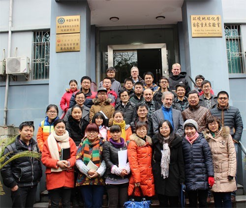 Around thirty persons on a stair outside a house. Photo.