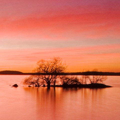 Solnedgång över en sjö. Himlen är röd. Foto.
