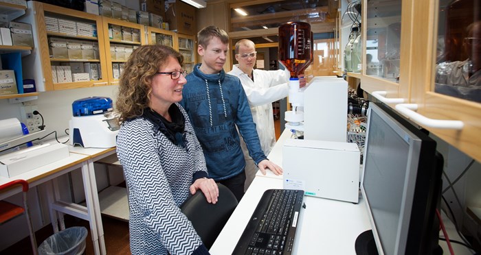 Tre personer i ett laboratorium. Foto.