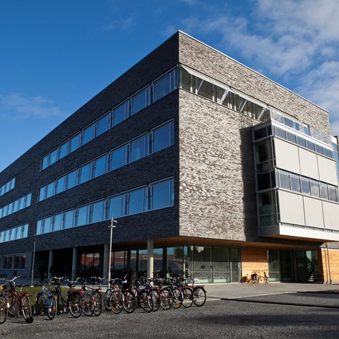The MVM house with a dark brick facade on campus Ultuna and bikes in the foreground. Photo.