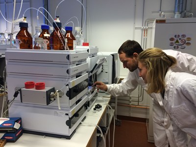 Two chemists inspecting an analysis instrument