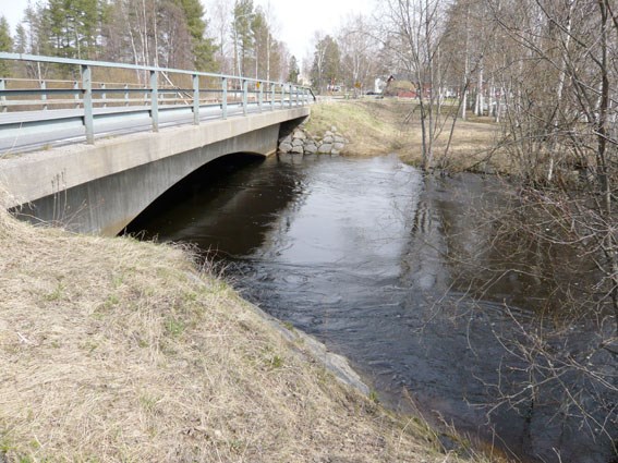 Vattendrag med bilbro över. Foto.