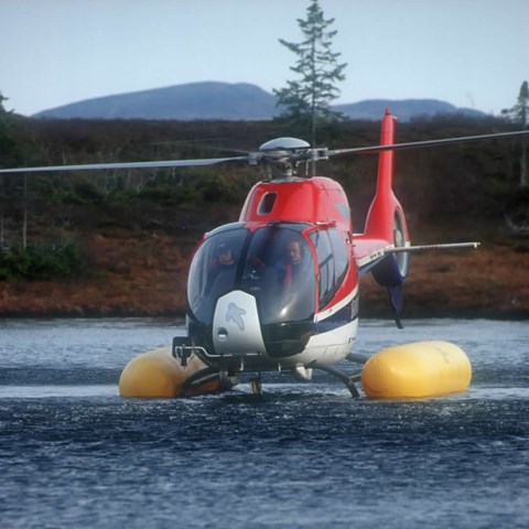 Helicopter above the surface a lake. Photo.