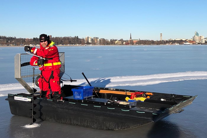 Man stående i hydrokopter borrar hål i isen. Foto.