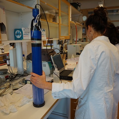 Kvinna på laboratorium som håller i en sond. Foto.