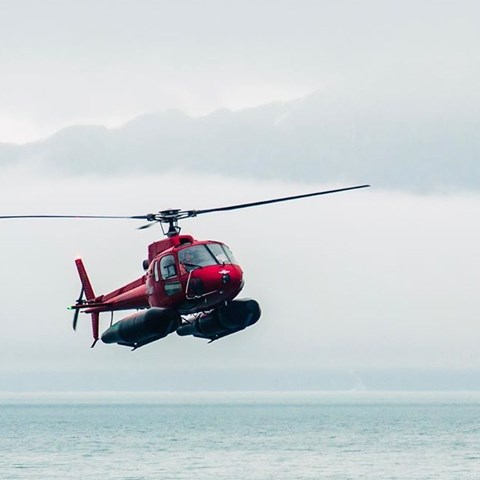 Helikopter ovanför sjö. Foto.
