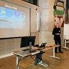 Man ståroch pratar framför en presentation. Foto.