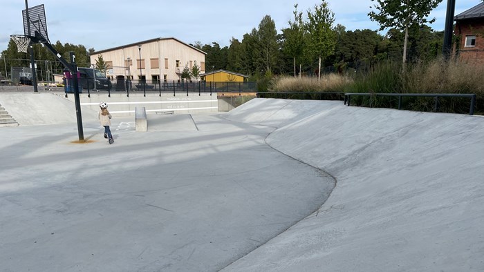 Torr skatepark med liten skateare. Foto.