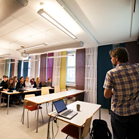 Föreläsare och studenter i en föreläsningssal, foto.