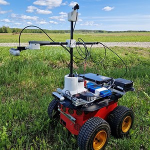 A robot on wheels in a field.