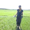  A woman walks in a field and holds a measuring device.