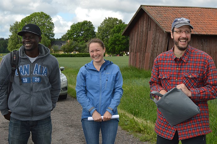 Thress smiling researchers in field.