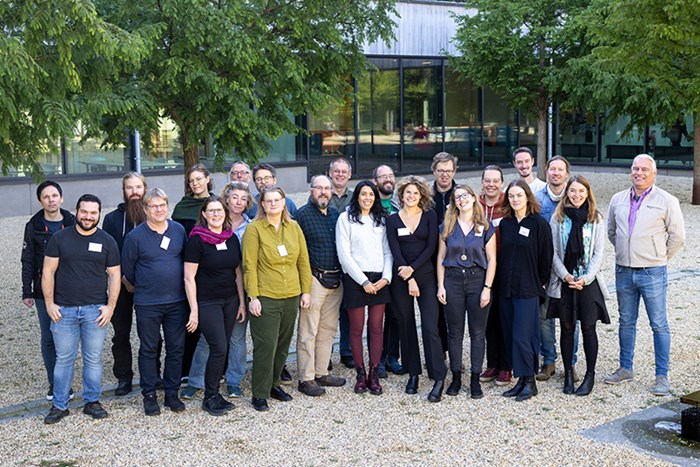 Gruppbild på forskare på ljus gårdsplan. Foto