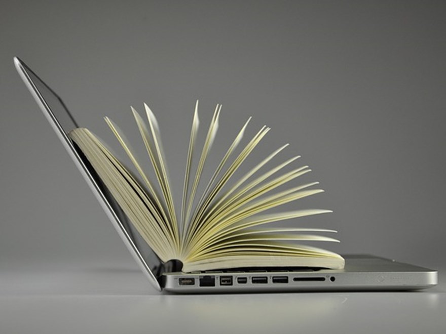 Laptop with book inside, photo.