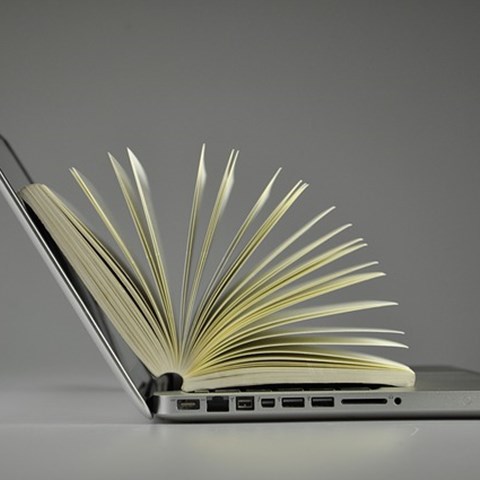 Laptop with book inside, photo.
