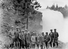 Old group portrait of men in front of a waterfall, photo