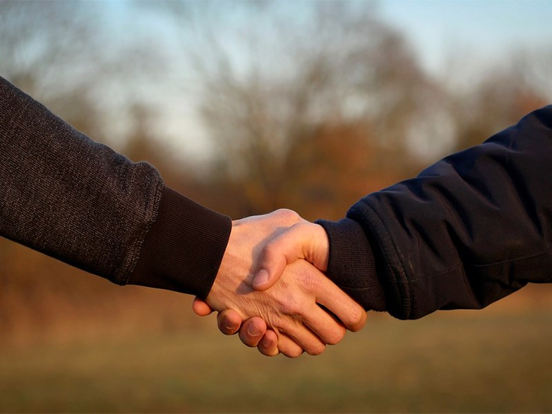 A handshake outdoors, photo.
