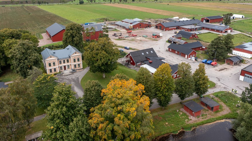 Flygbild över Sötåsens naturbruksgymnasium, olika lantbruksbyggnader utspridda i ett jordbrukslandskap.