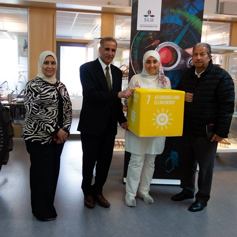 Shimaa Khatab, Gouda Kamel and Fawzy Ali from Heliopolis University for Sustainable Development (HUSD), Egypt and Dalia Abdelfattah, director of studies of the SSFEB research school stand in front of a SLU banner while holding a cube of the sustainable development goal 7 during their visit to the department of energy and technology, May 2023.