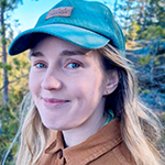 En kvinna med skog i bakgrunden.