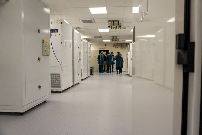 Corridor with white growth cabinets on both sides and a group of people at the end of the corridor