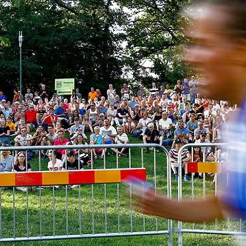 An orienteer runs with the audience in the background, photo.