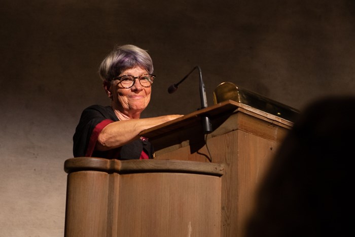 A cheerful Monika Stridsman, honorary doctor of forest sciences, at the podium of Rikssalen at Uppsala castle.