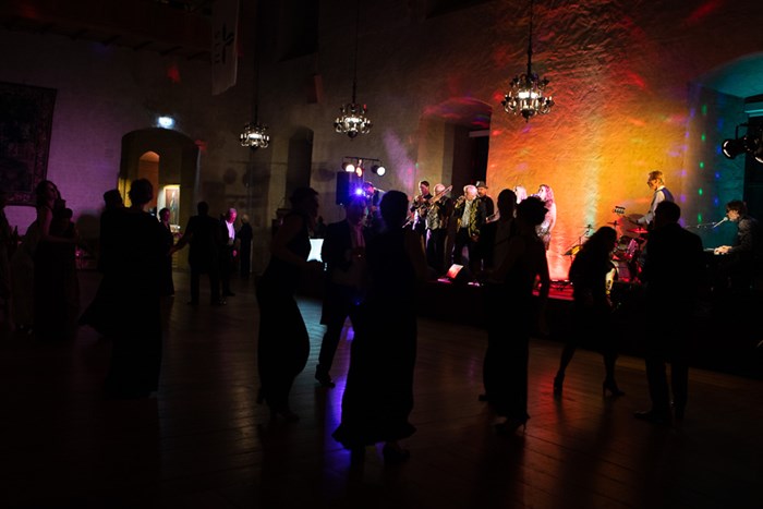 Dark silhouettes of people dancing to the music performed by Soul Pack. Colourful lights on stage.