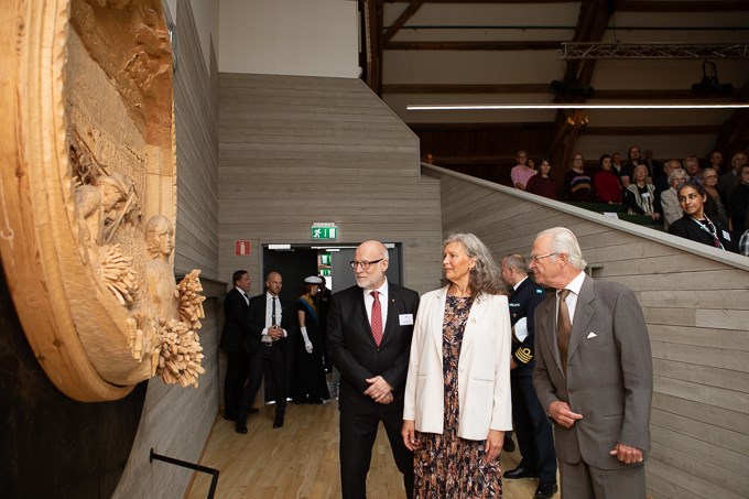 Bild av kungen, SLU:s rektor och landshövdingen som tittar på träskulpturen i Loftets hörsal. 