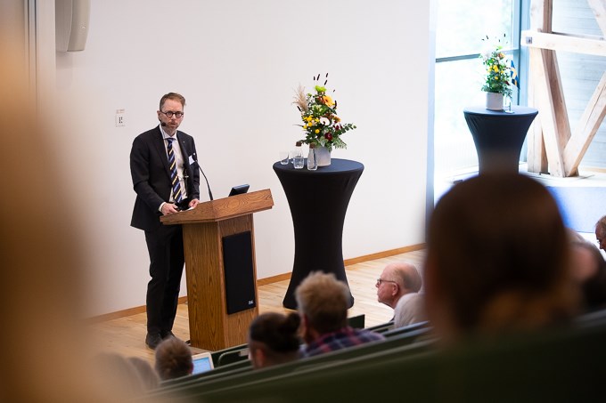 Bild av Mattias Lundblad som står vid talarpulpeten i Loftets hörsal.