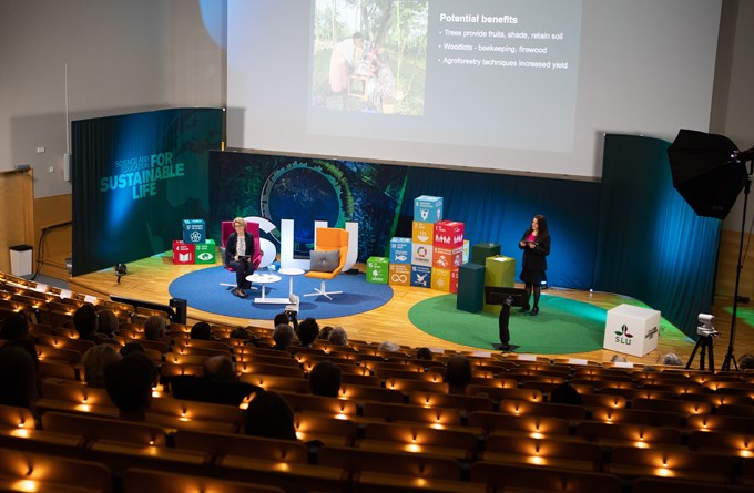 Picture of Flora Hajdu giving her inauguration lecture on stage in the auditorium of SLU Uppsala. On stage is also Malin von Essen.
