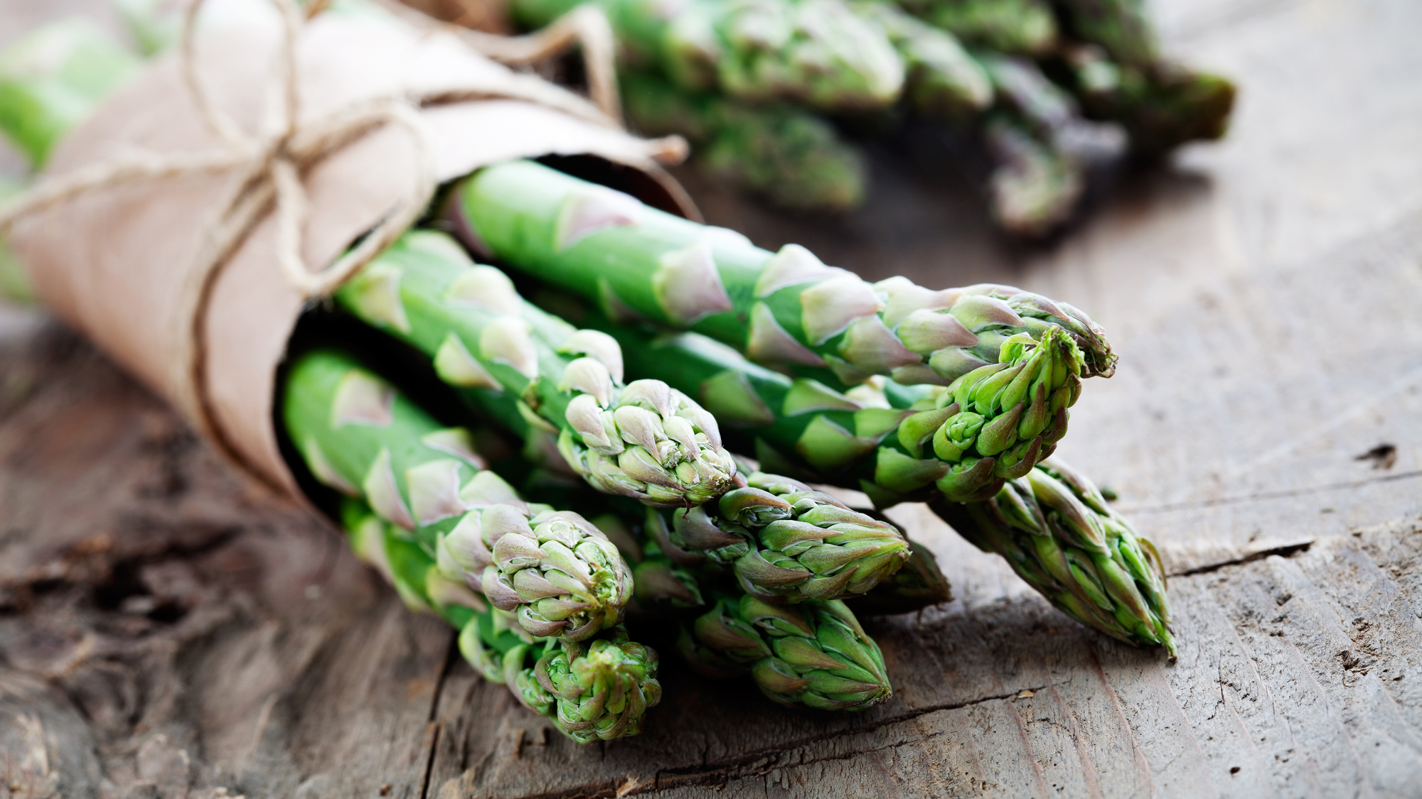 En knippe sparris på ett bord. Foto.