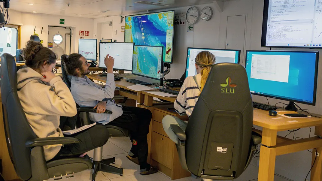 Interior of room with people working om computers