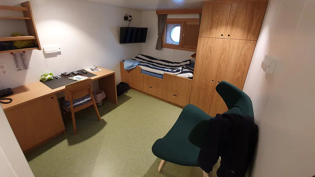 Inside of cabin with bed and desk