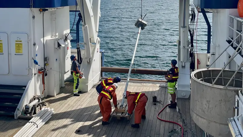 En lång sedimentkärna vinschas upp på Sveas däck