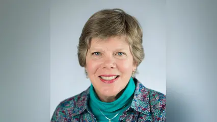 A smiling woman in a blue shirt.