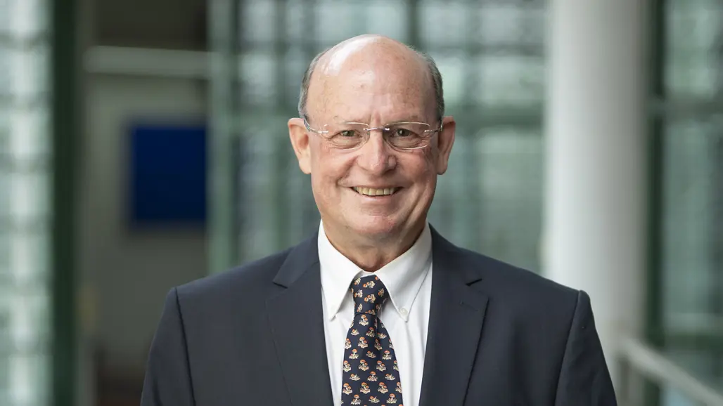 A smiling man in a dark suit.