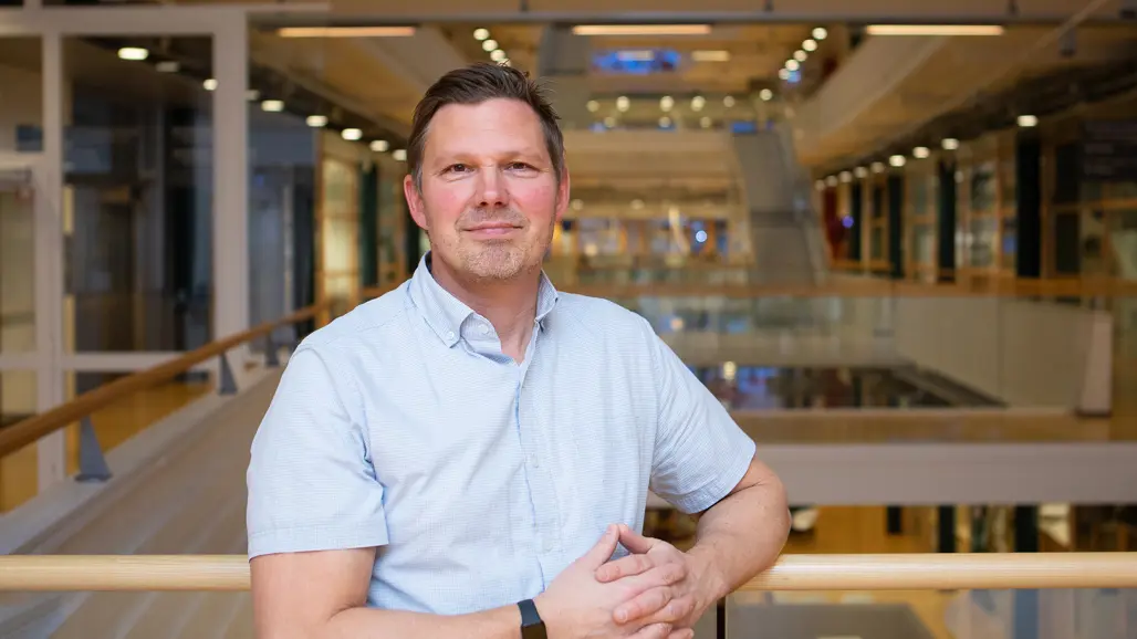 Portrait of a man in a light shirt in a modern indoor environment.