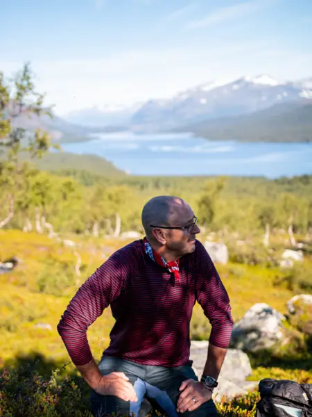En man i fjällen nära en sjön