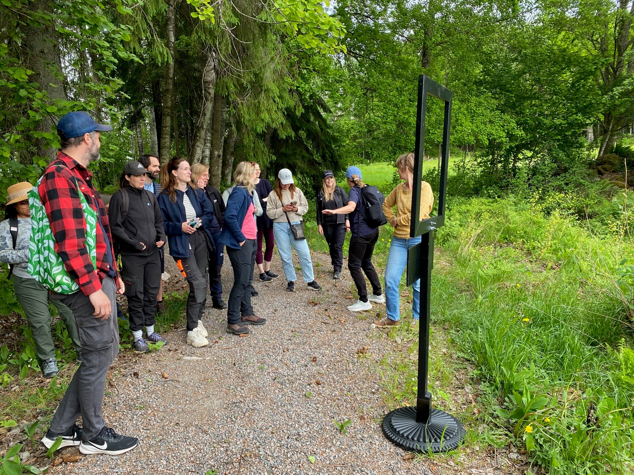Personer utomhus i naturen vid en svart ram