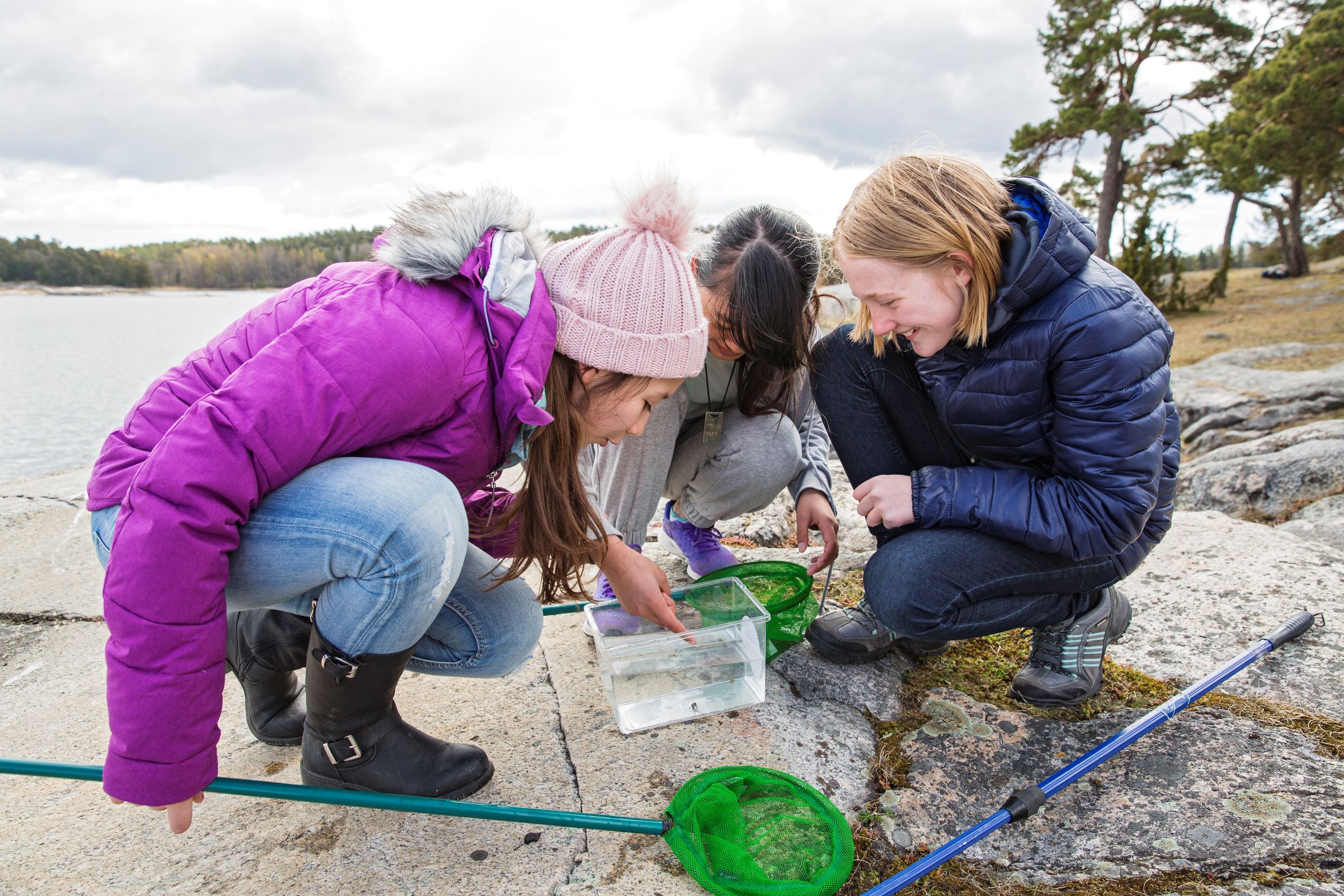 Barn på en klippa vid vatten