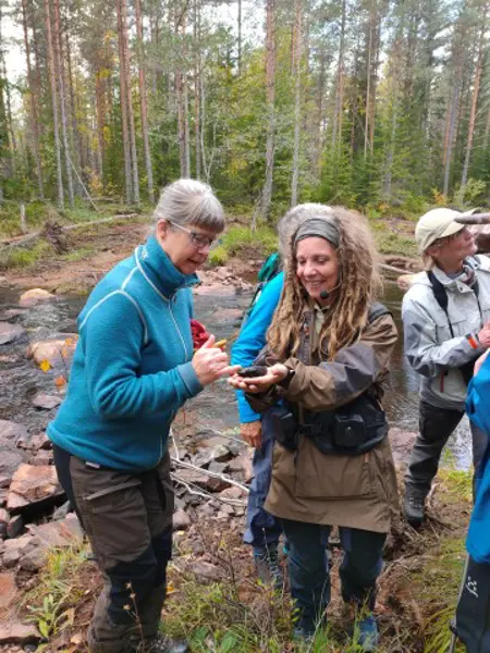 En kvinna visar en levande flodpärlmussla på guidning.