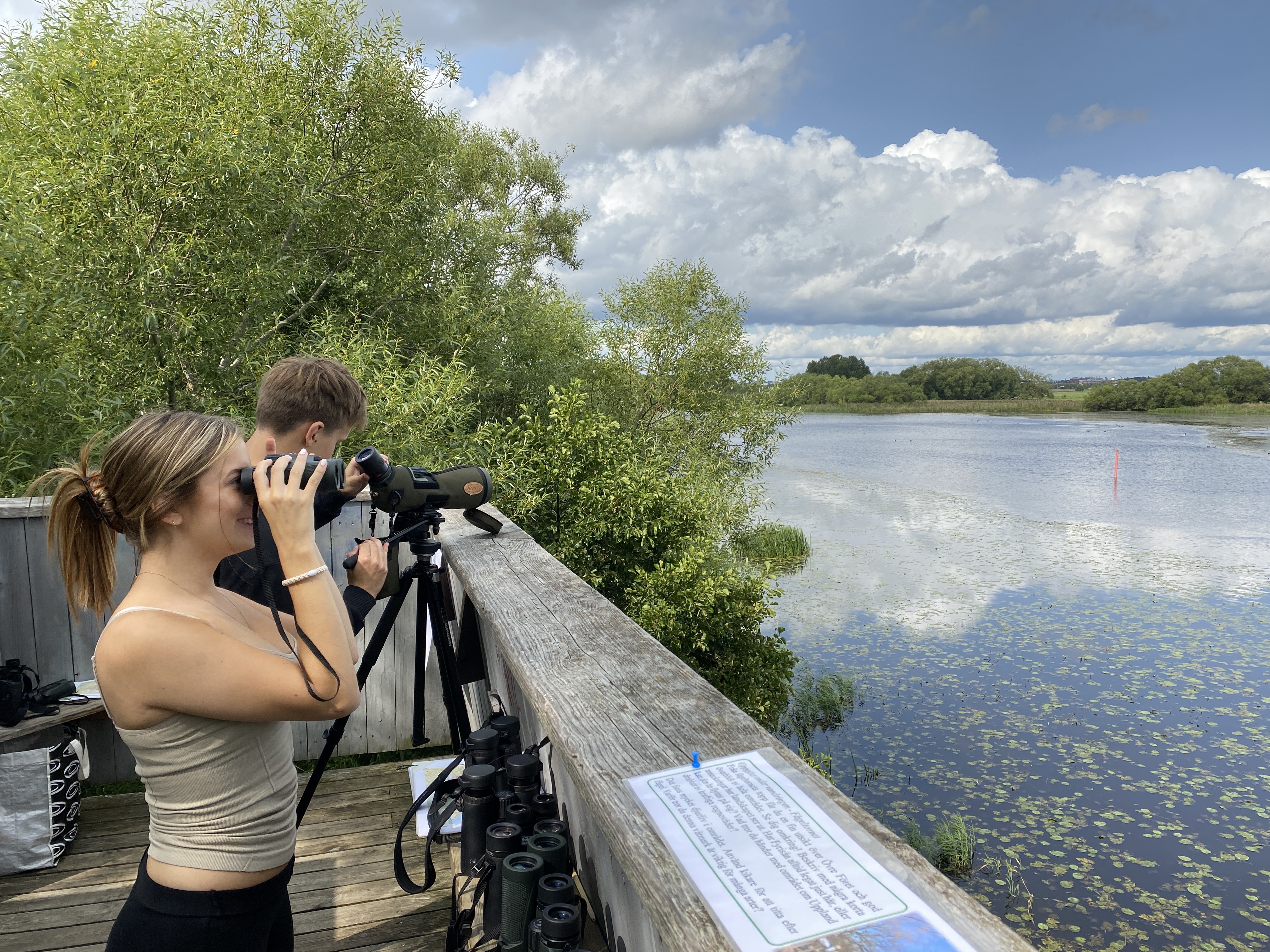 Två unga personer tittar på en å