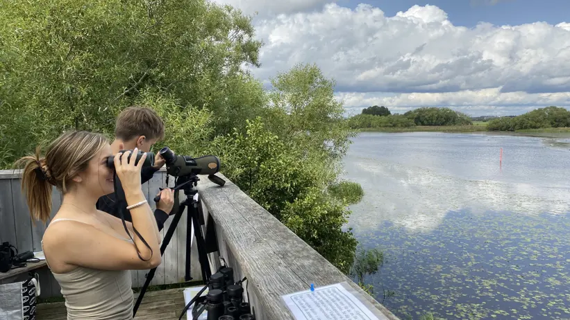 Två unga personer tittar på en å