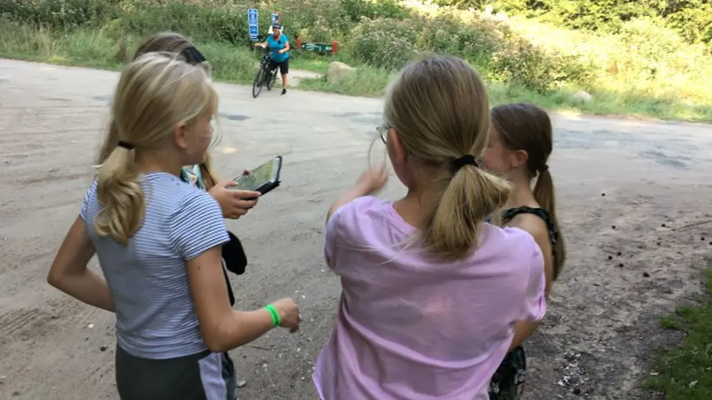 Några barn tittar på en mobiltelefon