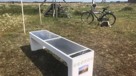 Solcellsdriven mobilladdningsstation i form av en bänk.