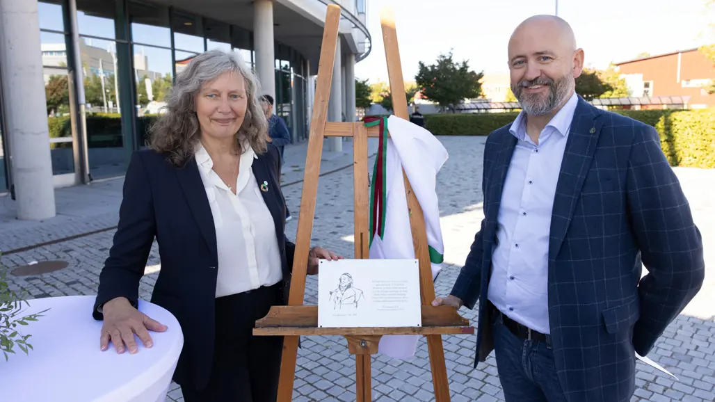 Rektor Maria Knutson Wedel och dekan Nils Fall avtäcker plaketten till Peter Hernqvists plats framför VHC-huset. Plaketten är silverfärgad i ungefär A5-format och innehåller en skiss av Peter Hernqvist i profil och en beskrivande text. Plaketten är placerad mittemellan rektor och dekan på ett trästaffli.